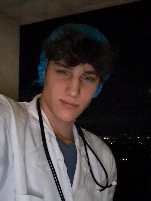 Orka in a white coat with a stethoscope, city lights behind